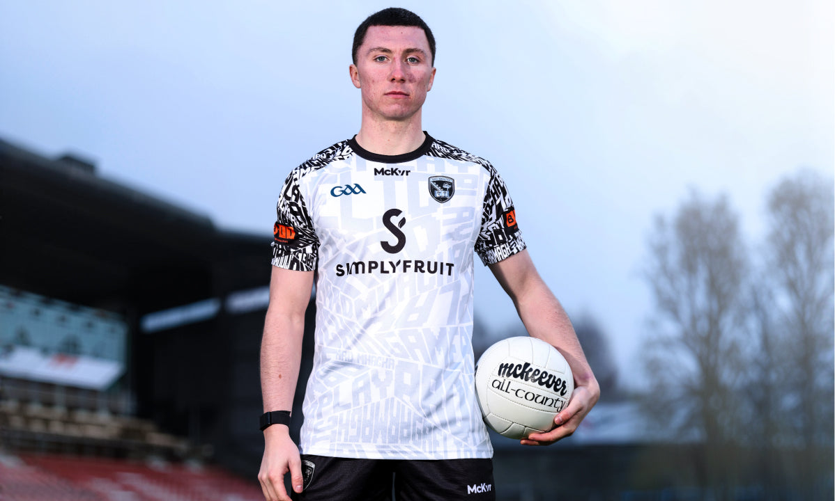 GAA player in a McKvr jersey holding a football